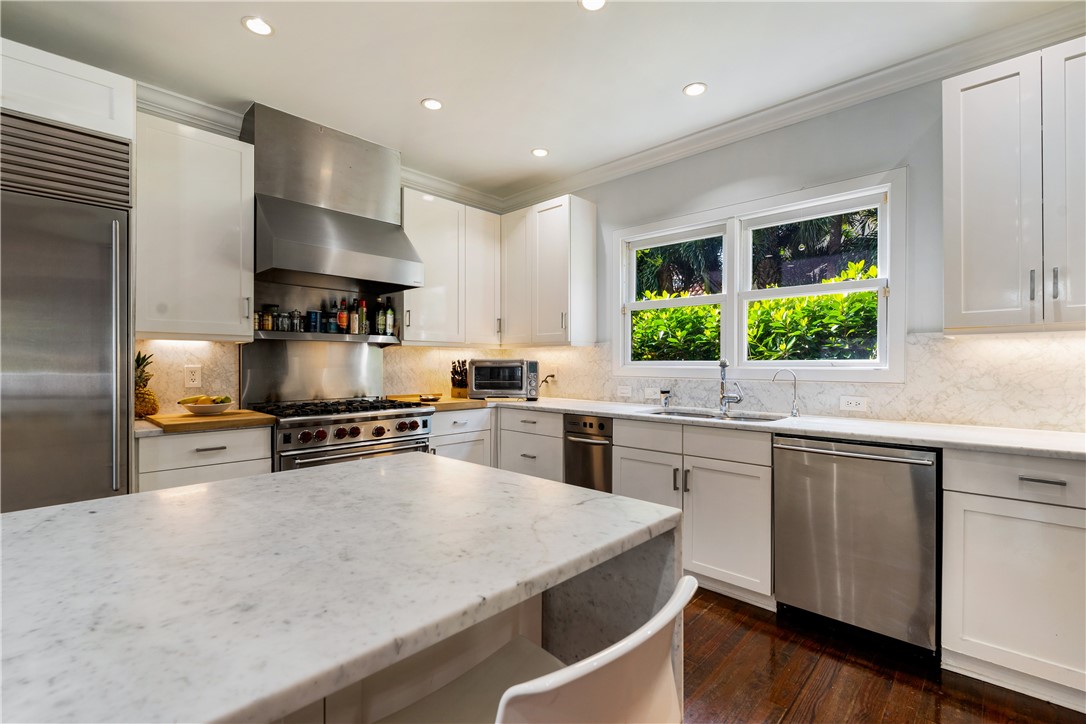 975 Riomar Drive Vero Beach, FL 32963 - Photo 21 of 34 a kitchen with stainless steel appliances a sink a stove a refrigerator cabinets and wooden floor