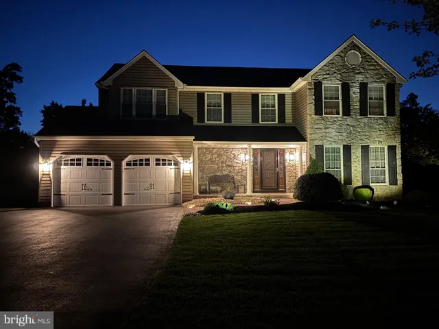 a view of a big house with a big yard and large trees