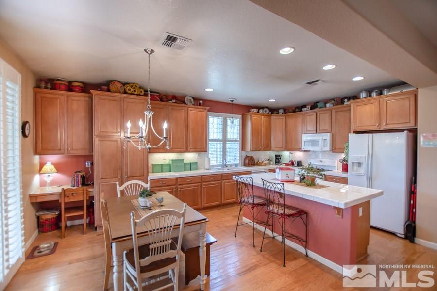 10655 Cedar Bend Court Reno, NV 89521 - Photo 2 of 16 a kitchen with sink refrigerator dining table and chairs