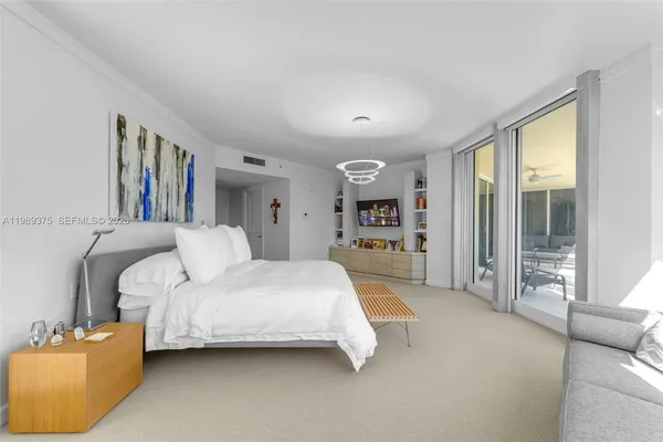 a spacious bedroom with a bed a couch and a large window