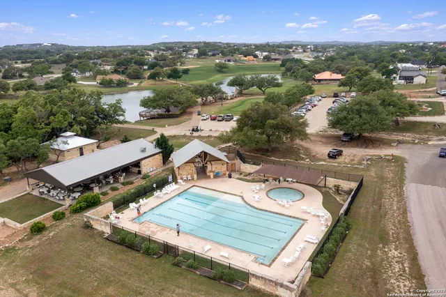 an aerial view of residential houses with outdoor space and trees