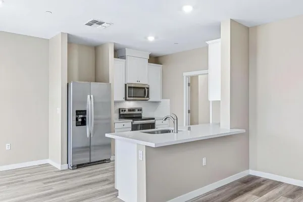 a kitchen with stainless steel appliances a refrigerator sink and microwave
