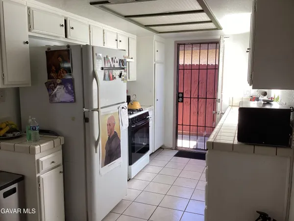 a white refrigerator freezer and a stove sitting inside of a kitchen