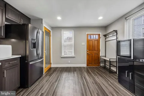 a kitchen with stainless steel appliances wooden floors and large window