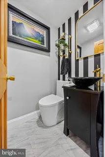 a bathroom with a toilet a sink and mirror
