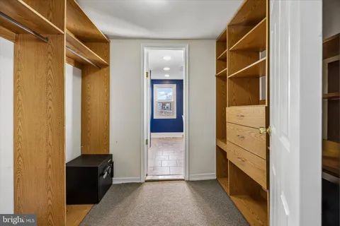 a view of a hallway with wooden shelves