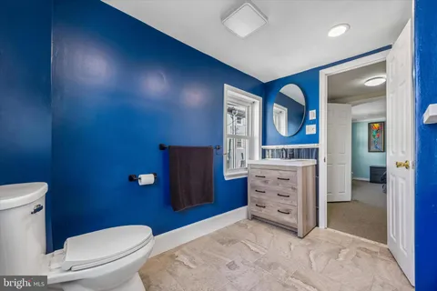 a bathroom with a toilet a sink and mirror