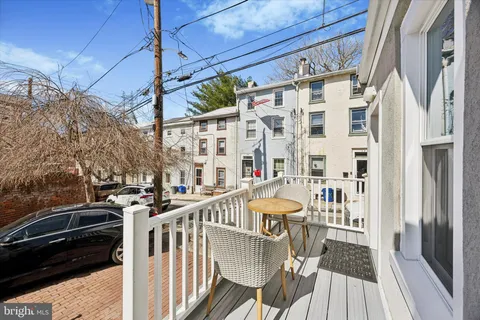 a view of a balcony with chairs and wooden floor
