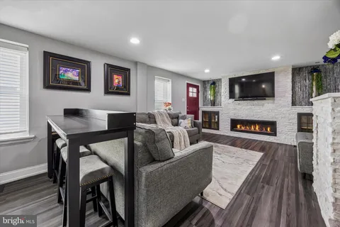 a living room with furniture a flat screen tv and a fireplace