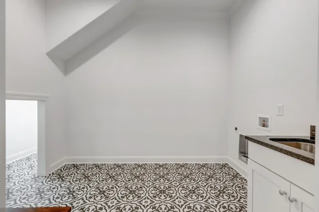 a kitchen with stainless steel appliances kitchen island granite countertop a refrigerator a stove and white cabinets with wooden floor