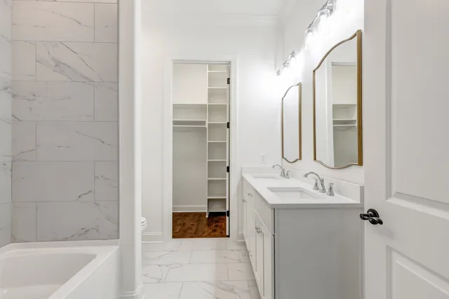a spacious bathroom with a toilet sink and mirror