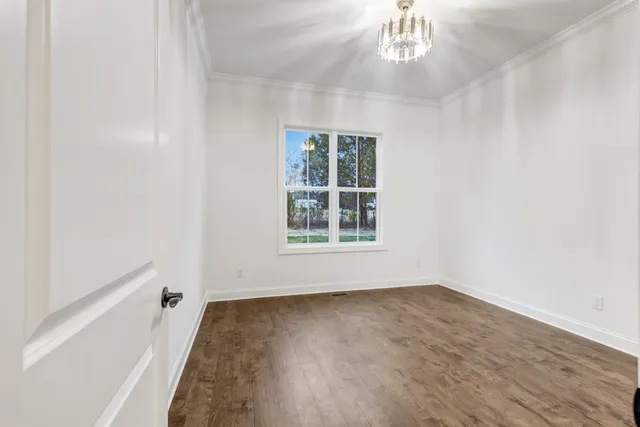 wooden floor in an empty room with a chandelier