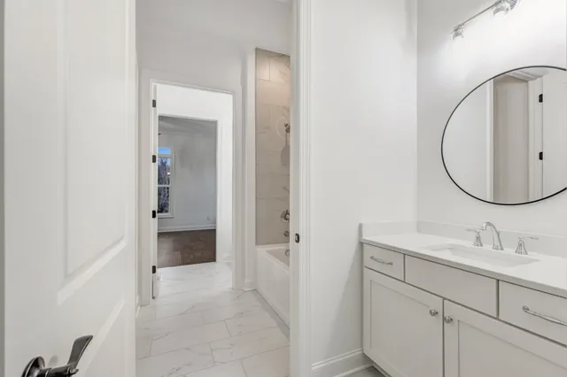an empty room with wooden floor ceiling fan and windows