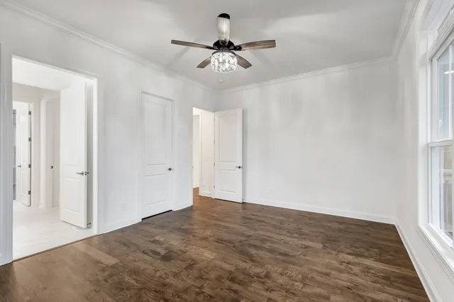 a view of a livingroom with a ceiling fan and windows
