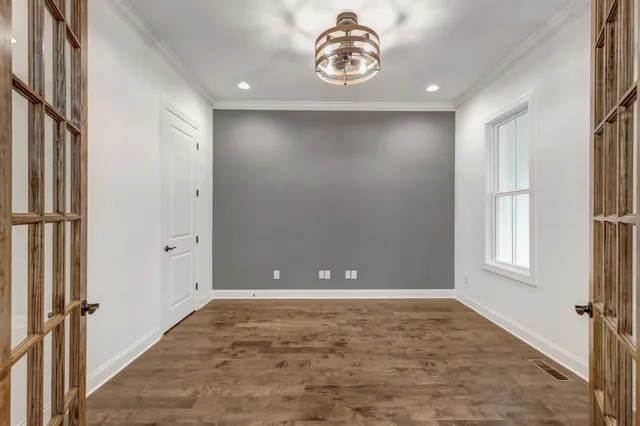 a view of empty room with wooden floor and fireplace