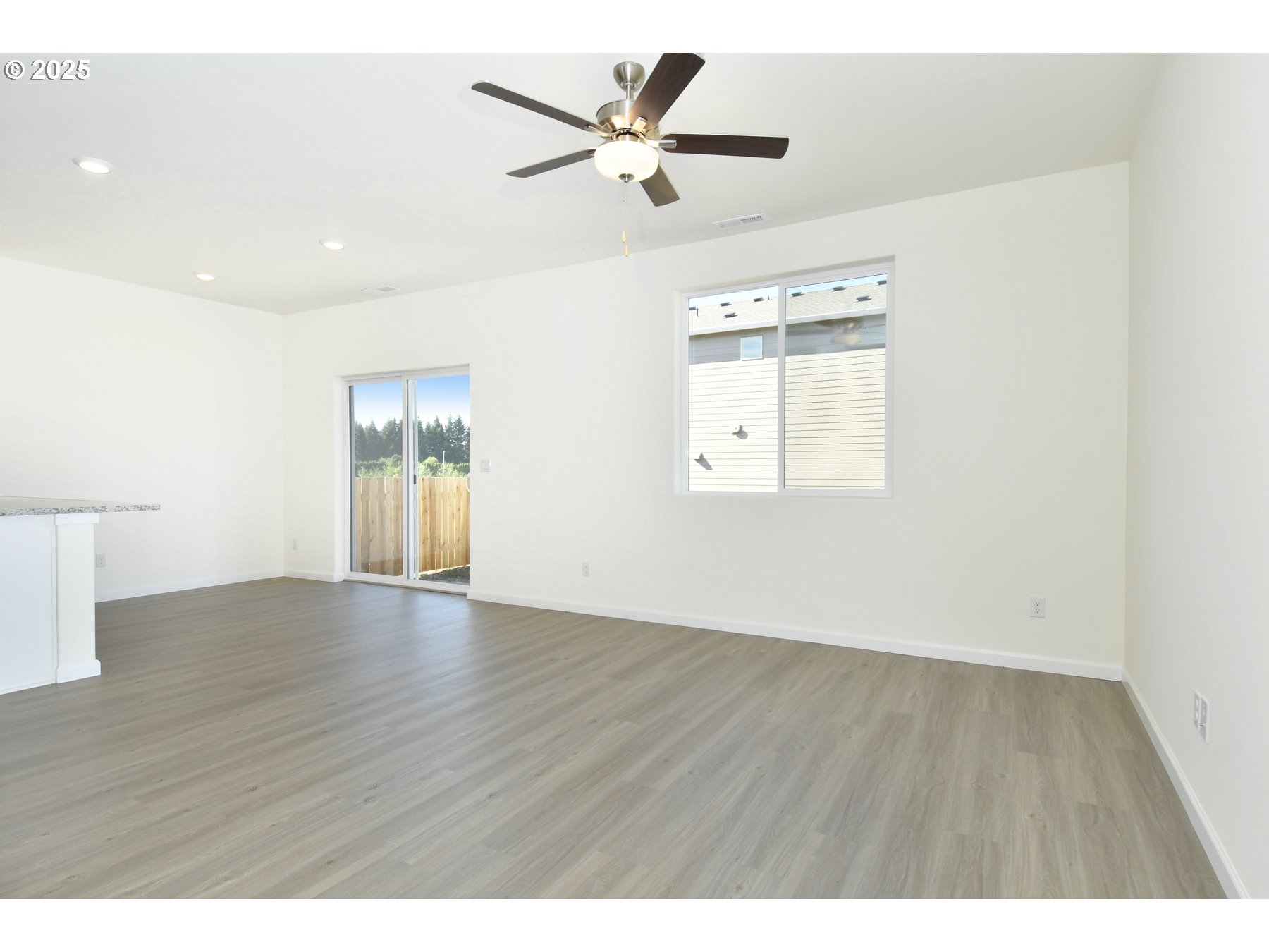 3933 Southwest Duniway Lane Gresham, OR 97080 - Photo 3 of 24 a view of an empty room with a window and wooden floor