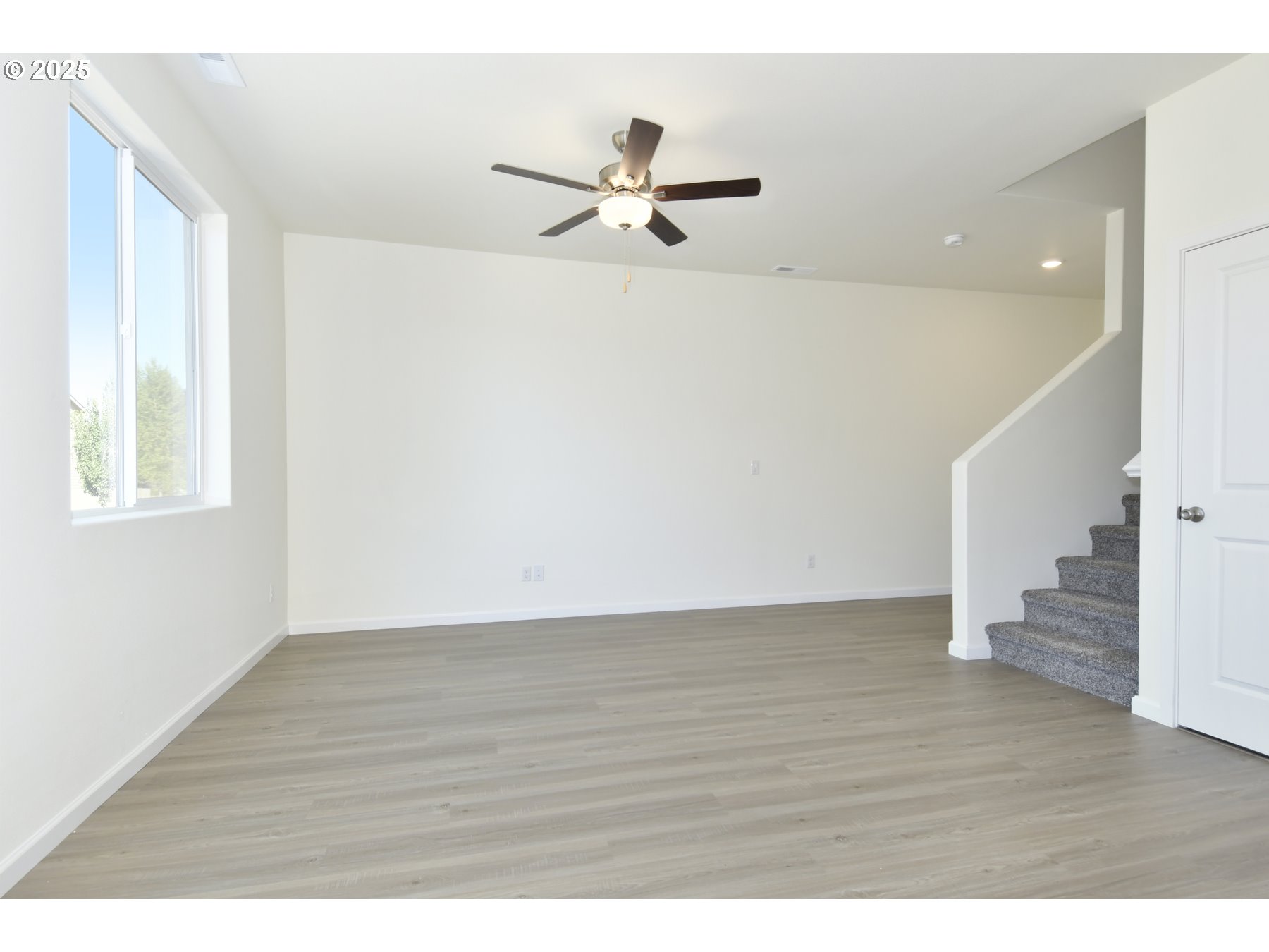 3933 Southwest Duniway Lane Gresham, OR 97080 - Photo 6 of 24 a view of empty room with wooden floor and fan