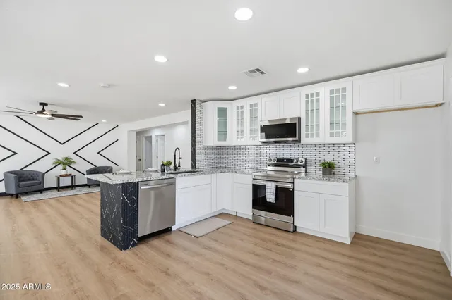 a kitchen with stainless steel appliances granite countertop a sink and cabinets