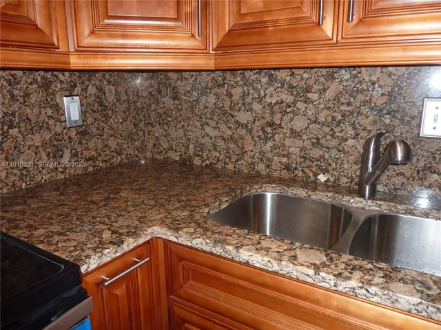 a kitchen with granite countertop a refrigerator stove and microwave