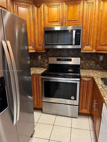 a kitchen with granite countertop a stove and a microwave oven