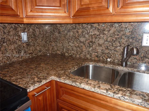 a kitchen with granite countertop a refrigerator stove and microwave