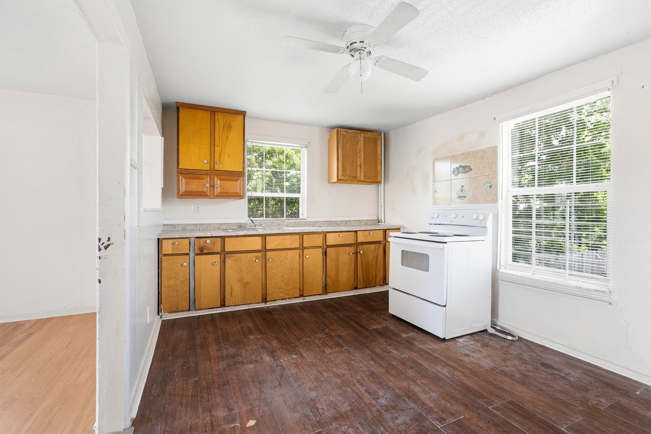 4233 Du Pont Street Houston, TX 77021 - Photo 5 of 14 The first floor unit kitchen features stylish laminate flooring, a ceiling fan, and a large window with privacy blinds, creating a bright, comfortable, and functional space for everyday living.