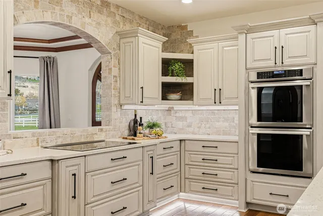 a kitchen with granite countertop a sink stainless steel appliances and cabinets