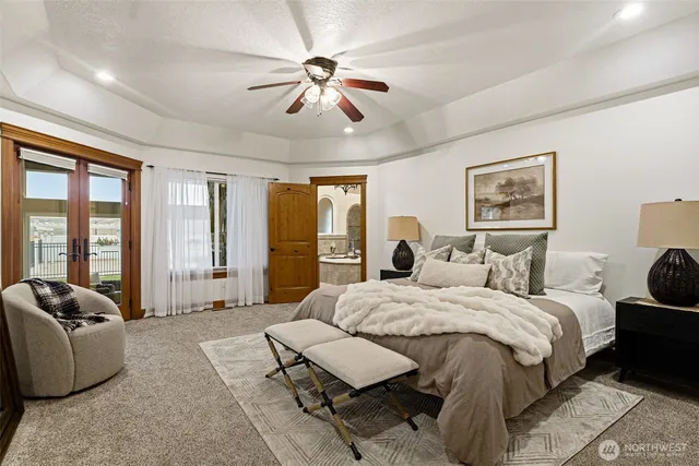a bedroom with a large bed couch and windows