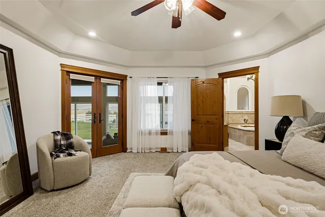 a bedroom with a bed couch and a large window