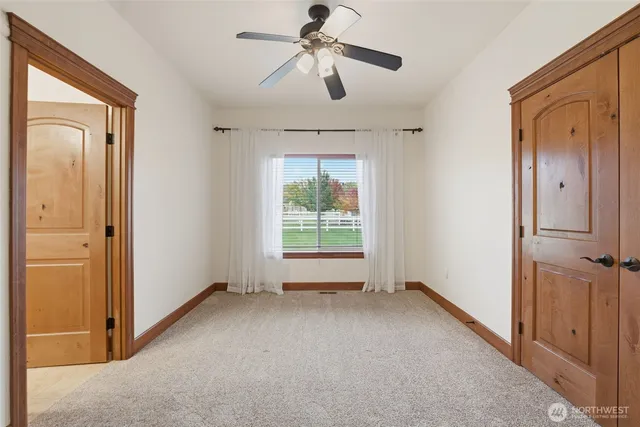 a view of empty room with window and ceiling fan