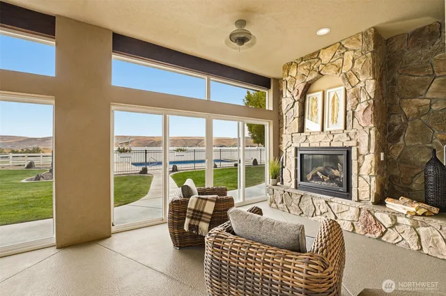 a living room with furniture and a floor to ceiling window next to a yard