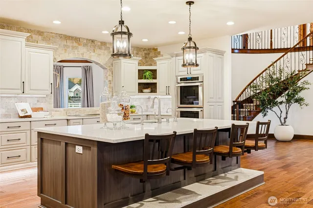 a dining hall with stainless steel appliances kitchen island granite countertop a dining table chairs and chandelier