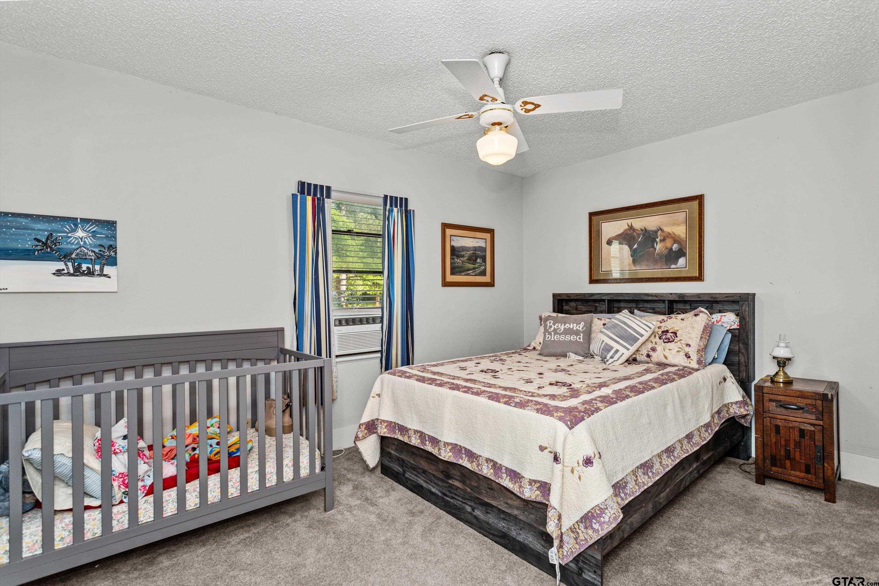 552 Highway 7 Crockett, TX 75835 - Photo 17 of 35 a bed sitting in a bedroom next to a window with a baby crib