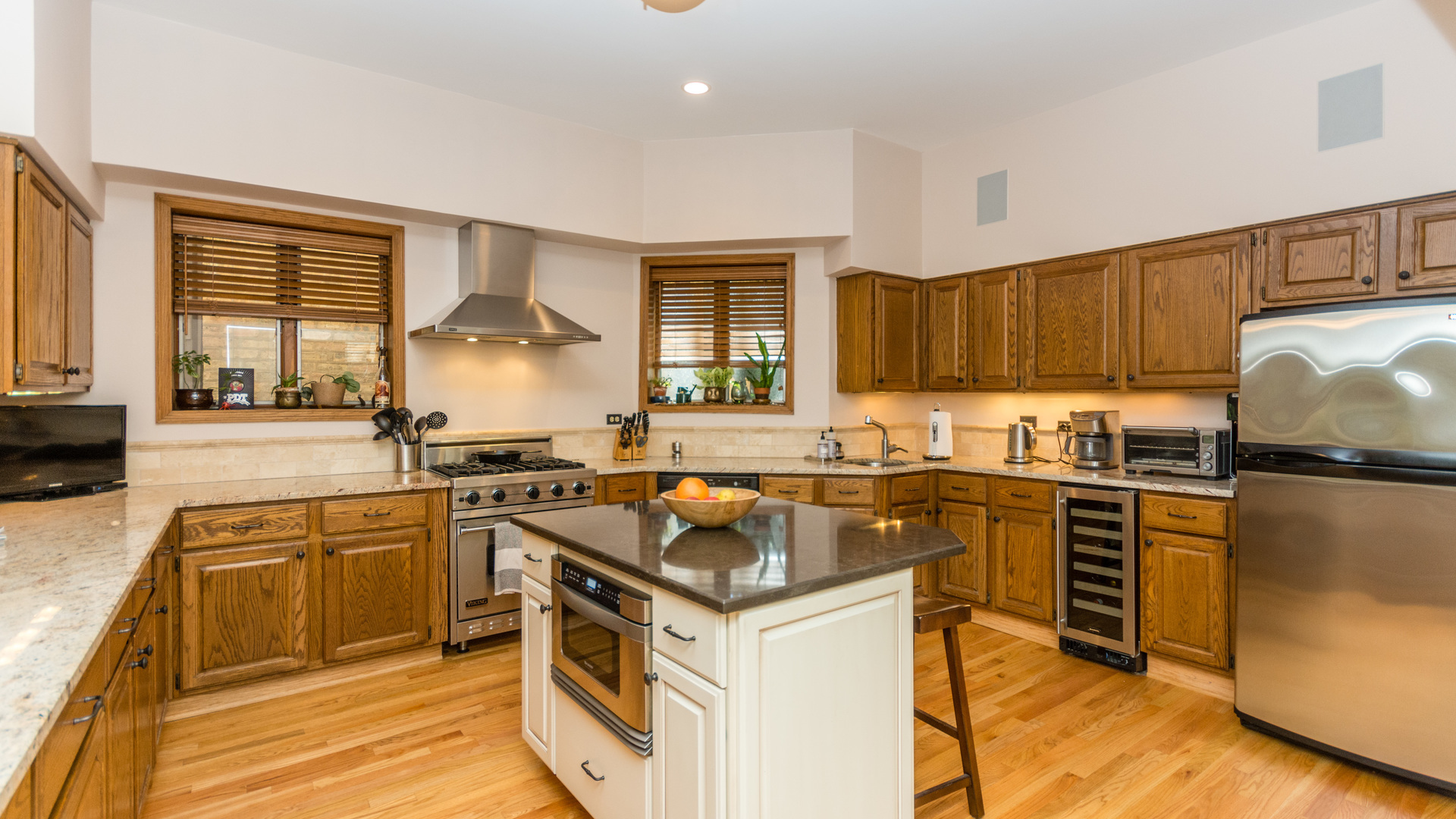 3810 North Fremont Street, Unit 2B Chicago, IL 60613 - Photo 7 of 22 a kitchen with stainless steel appliances granite countertop a stove top oven a sink dishwasher a refrigerator and cabinets with wooden floor