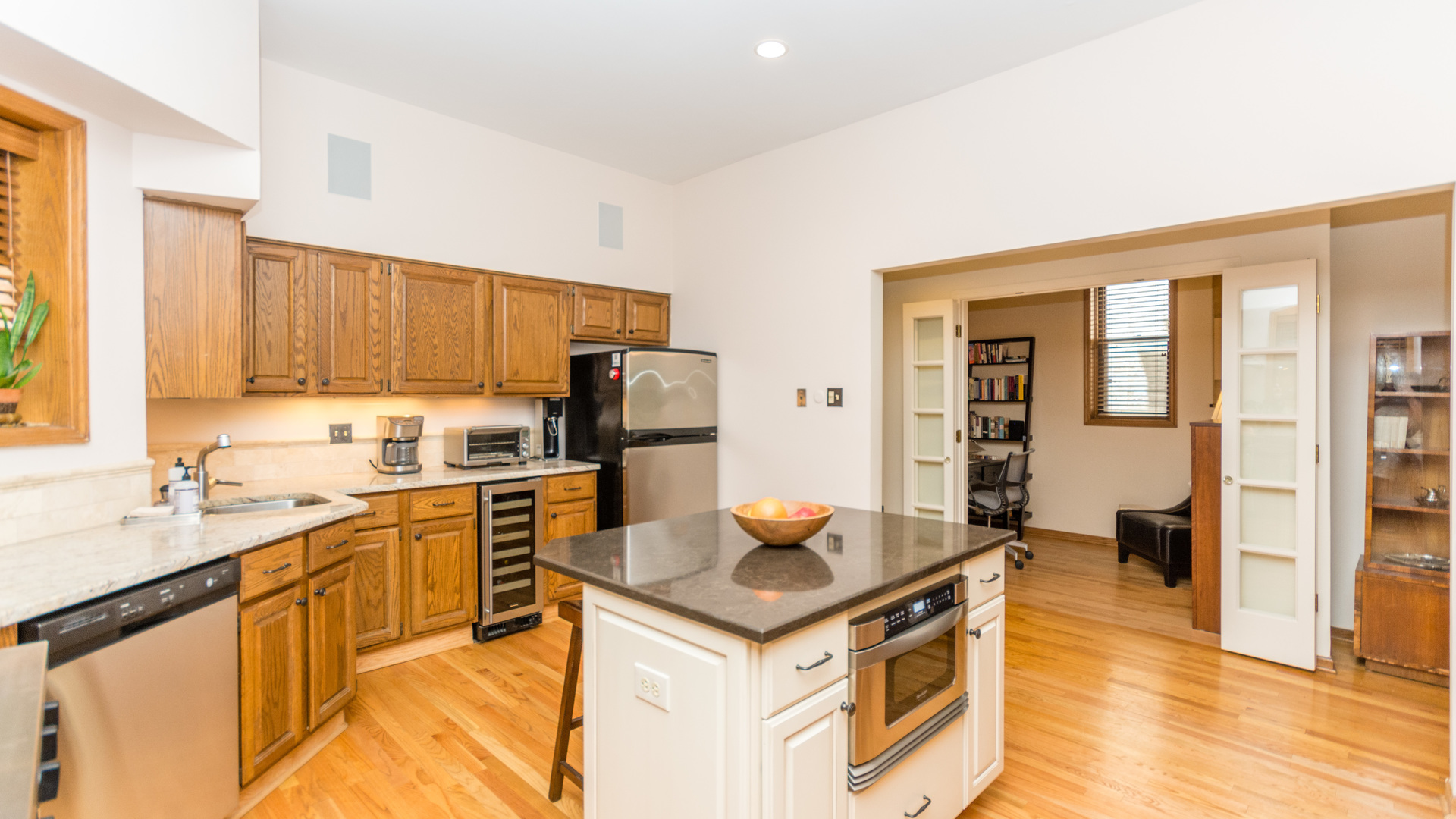 3810 North Fremont Street, Unit 2B Chicago, IL 60613 - Photo 9 of 22 a kitchen with stainless steel appliances granite countertop a stove top oven a refrigerator a sink and dishwasher with wooden floor
