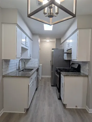 a kitchen with stainless steel appliances granite countertop a sink and stove