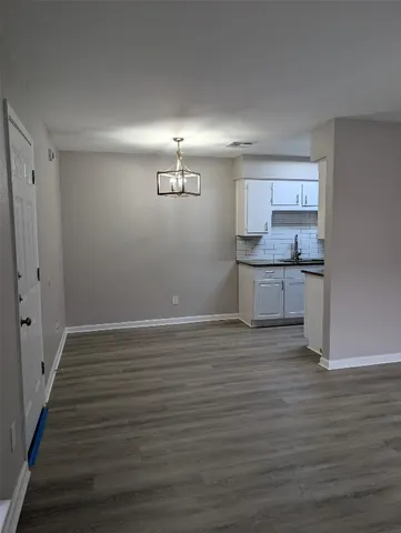 a view of a kitchen with a sink and dishwasher with wooden floor