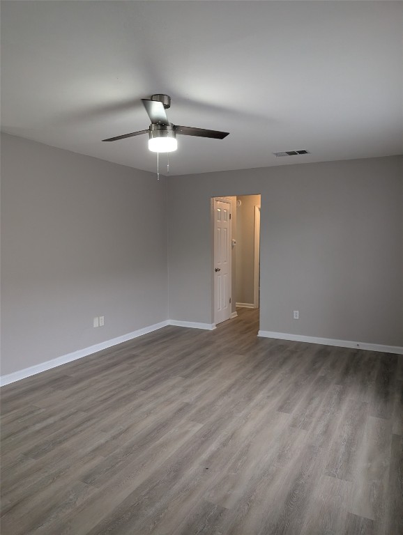 5102 Par Cove, Unit B Austin, TX 78744 - Photo 7 of 11 an empty room with wooden floor chandelier fan and windows