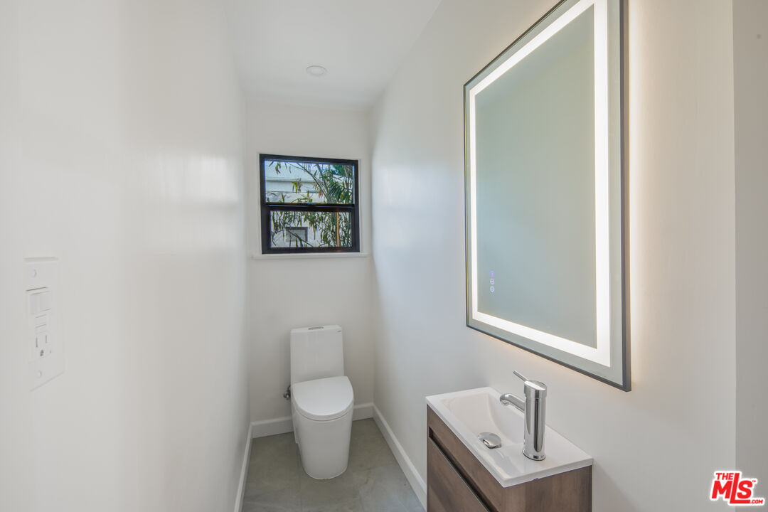152 South Roxbury Drive, Unit 6 Beverly Hills, CA 90212 - Photo 14 of 51 a bathroom with a toilet a sink and mirror