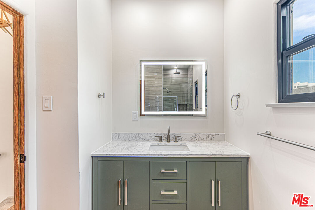 152 South Roxbury Drive, Unit 6 Beverly Hills, CA 90212 - Photo 17 of 51 a bathroom with a granite countertop sink and mirror