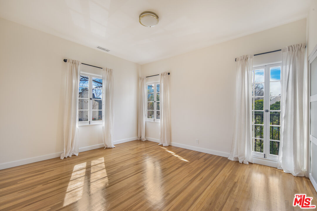 152 South Roxbury Drive, Unit 6 Beverly Hills, CA 90212 - Photo 19 of 51 a view of an empty room with wooden floor and a window