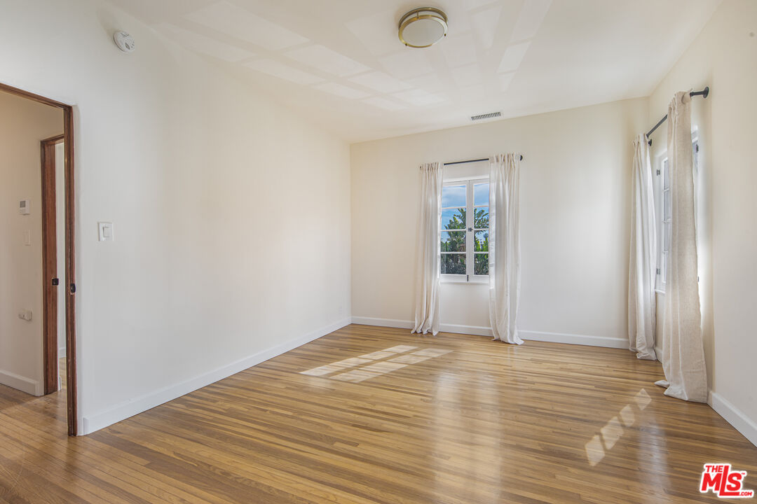 152 South Roxbury Drive, Unit 6 Beverly Hills, CA 90212 - Photo 21 of 51 a view of an empty room with wooden floor and a window