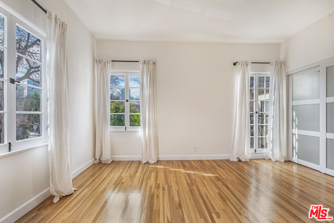 152 South Roxbury Drive, Unit 6 Beverly Hills, CA 90212 - Photo 22 of 51 a view of an empty room with wooden floor and a window