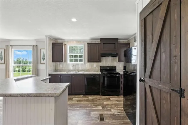 a kitchen with stainless steel appliances granite countertop a sink stove and cabinets