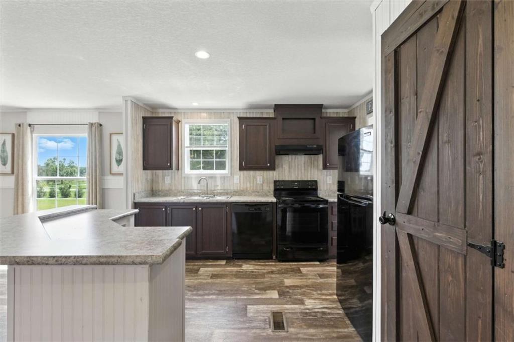 120 Beck Road Mount Airy, GA 30563 - Photo 13 of 30 a kitchen with granite countertop a stove a sink and a refrigerator