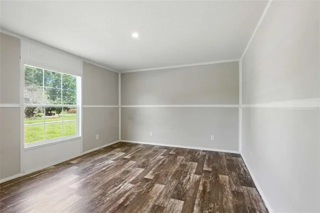 a view of empty room with wooden floor and entryway