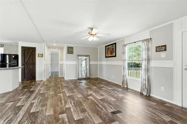 a view of a big room with wooden floor and windows