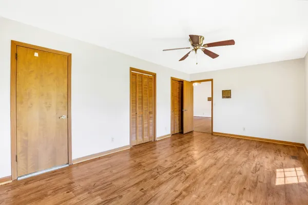 a view of room with wooden floor and ceiling fan