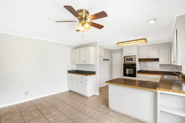 a kitchen with granite countertop white cabinets and stainless steel appliances