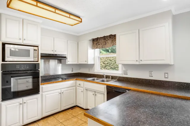 a kitchen with granite countertop a sink stainless steel appliances and cabinets